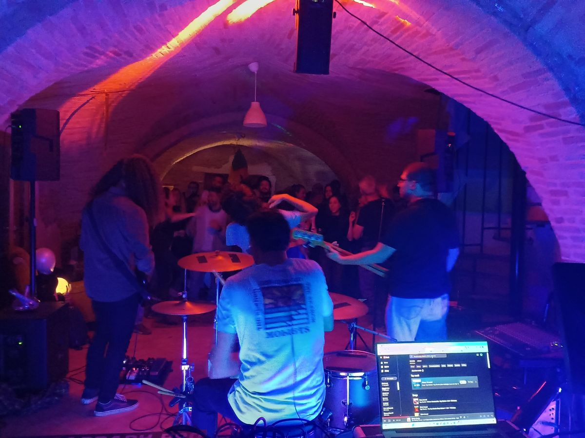 A Naturacustica live music event in a converted stone cellar with purple and orange lighting
