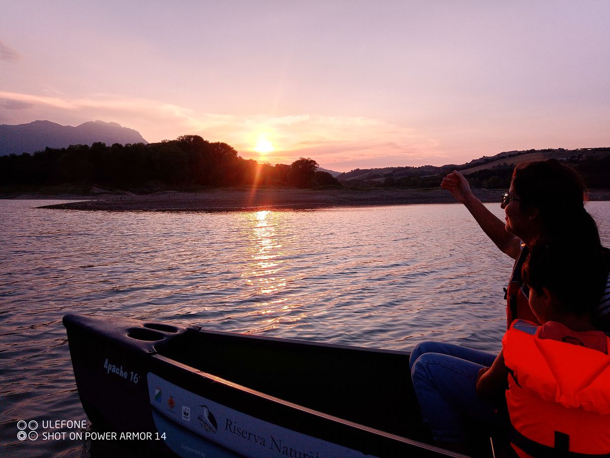Sunset over Penne Lake seen from a canoe, mountains silhouetted in the background